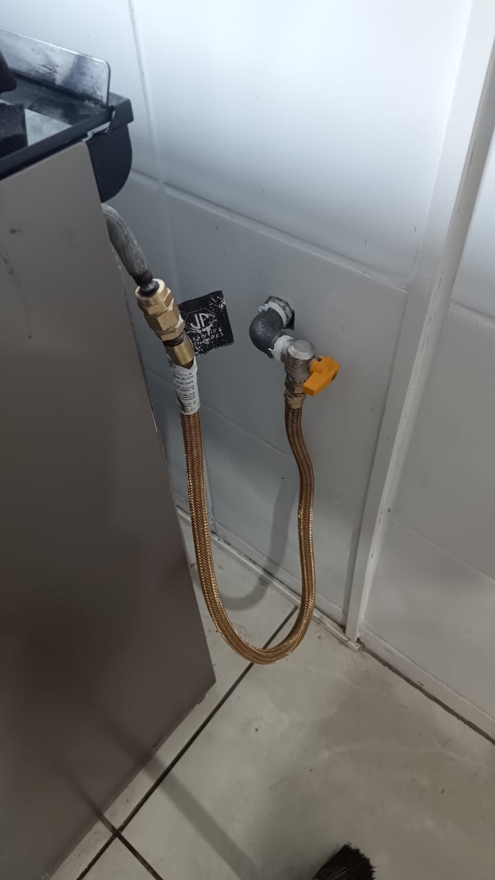 Conexões de gás flexíveis douradas conectadas ao aquecedor