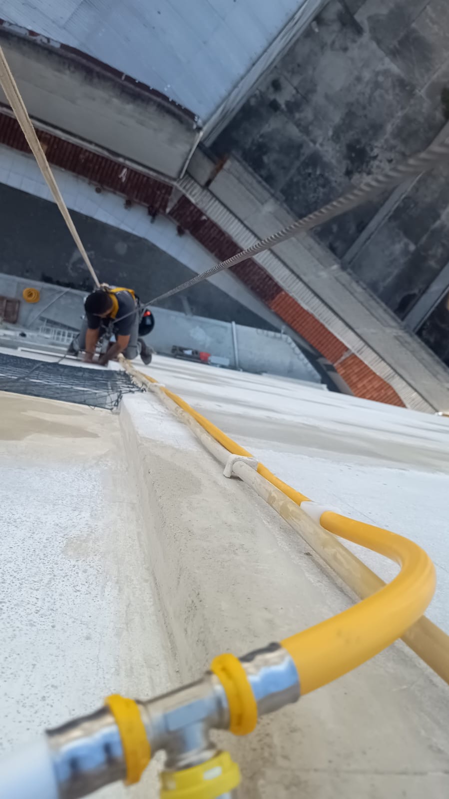 Técnico trabalhando em altura instalando tubulação de gás